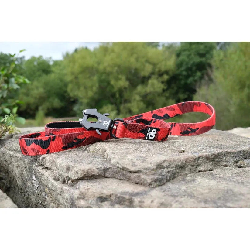 Red camo dog sport lead with silver clip resting on textured stone
