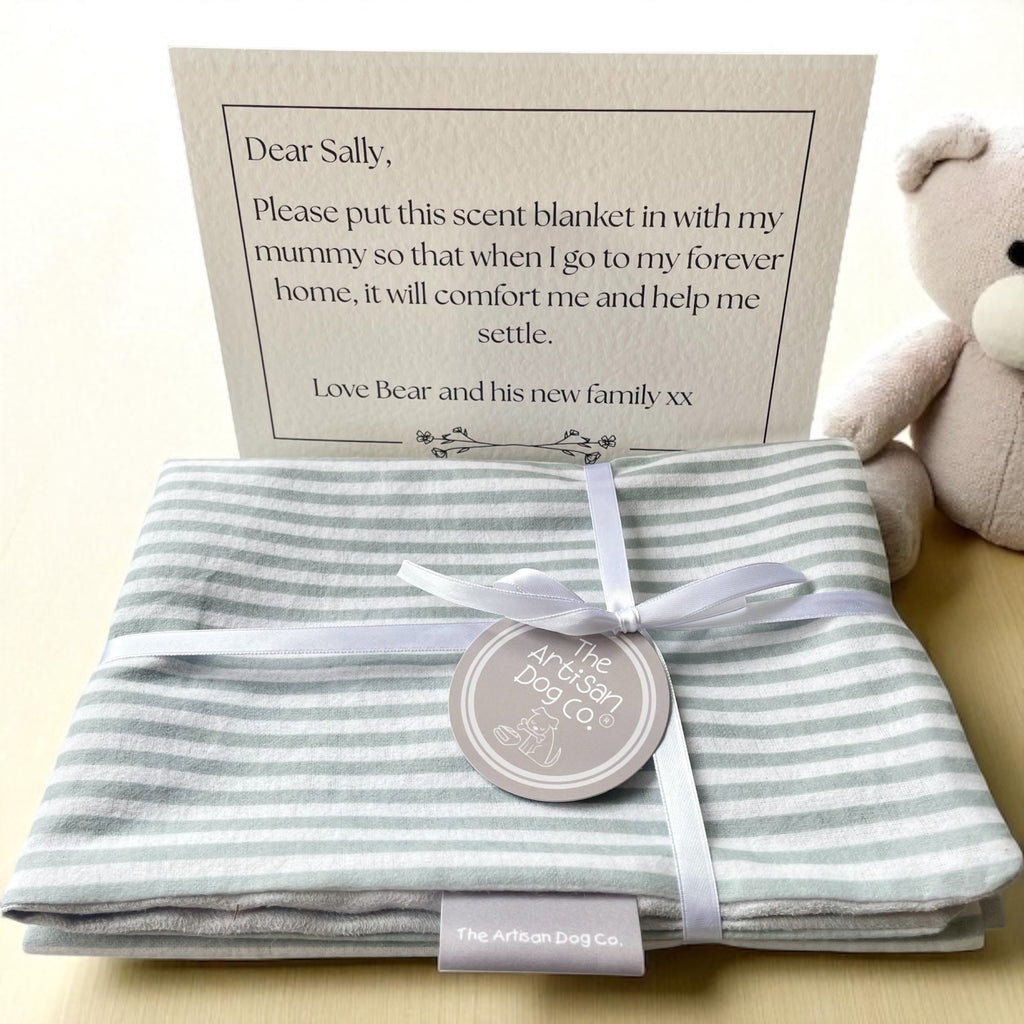 Striped grey-and-white scent blanket/mat folded with satin ribbon, circular tag, and letter