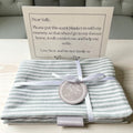 Striped grey-and-white scent blanket/mat with satin ribbon and circular tag, plus note card