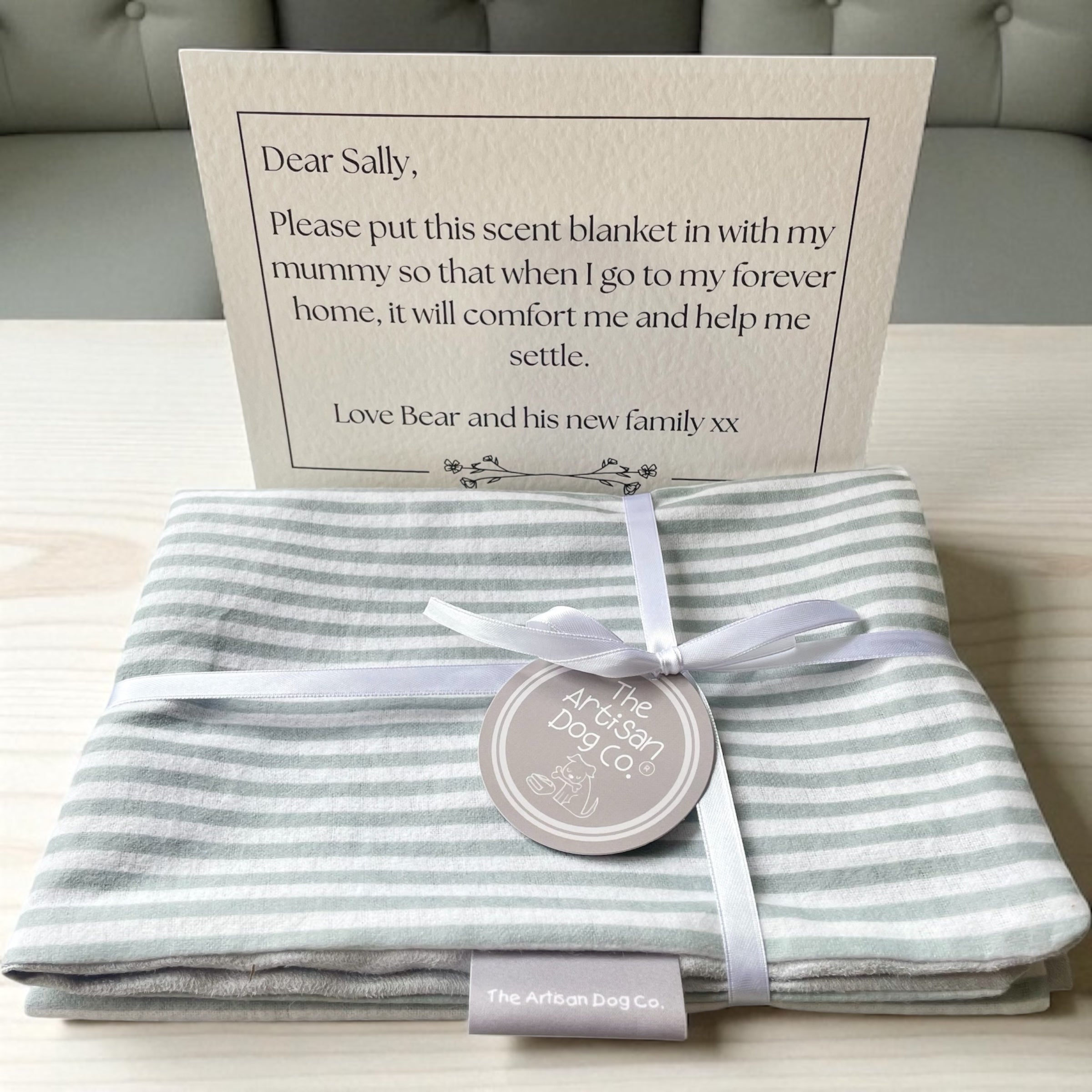 Striped grey-and-white scent blanket/mat with satin ribbon and circular tag, plus note card