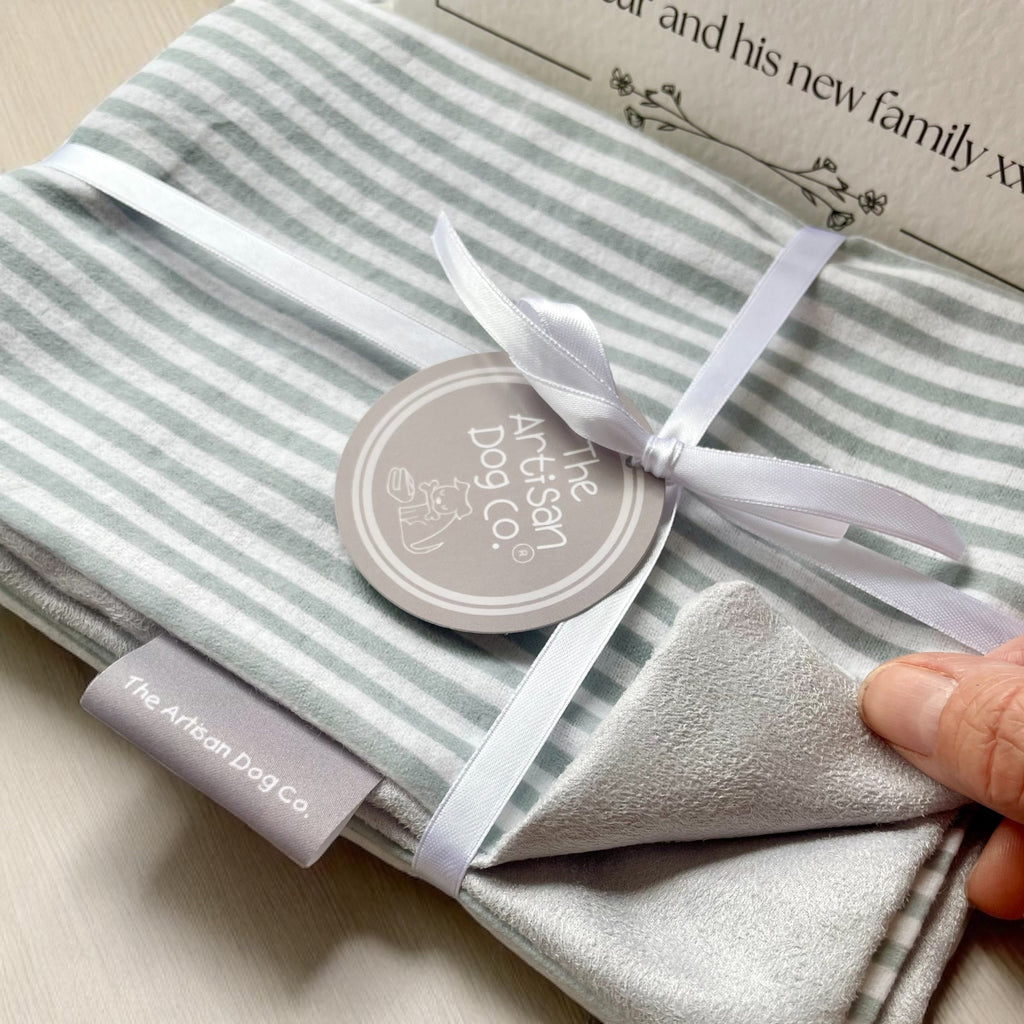 Striped grey-and-white scent blanket/mat with satin bow and circular tag, textured edge