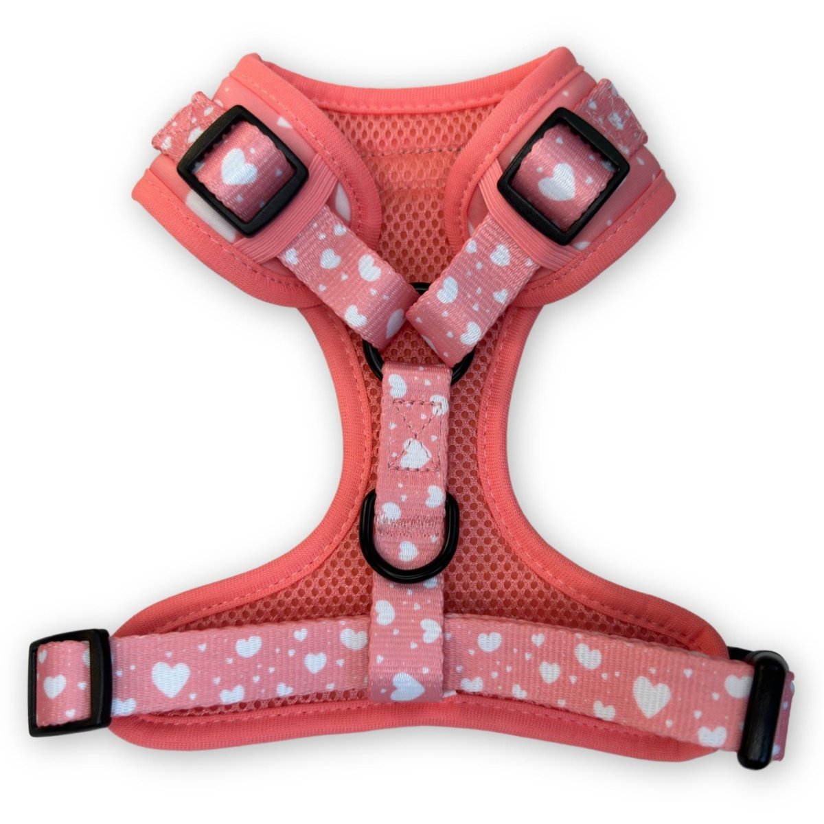 Pink dog harness with white hearts, chest buckles, and adjustable straps