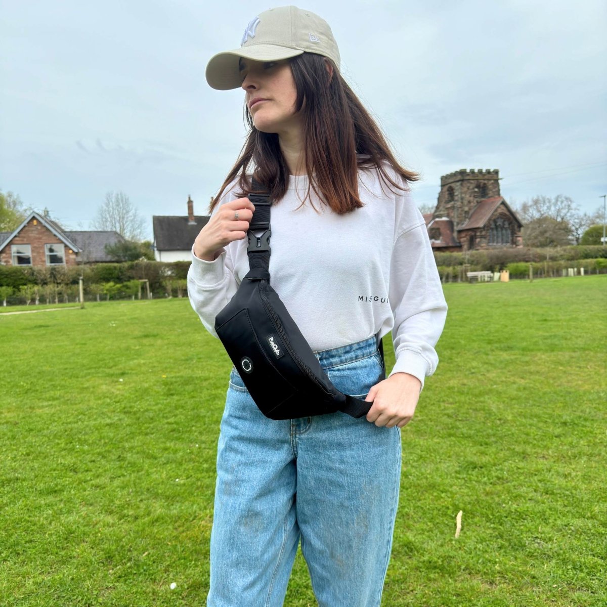 Black crossbody bum bag with front zip and circular logo patch