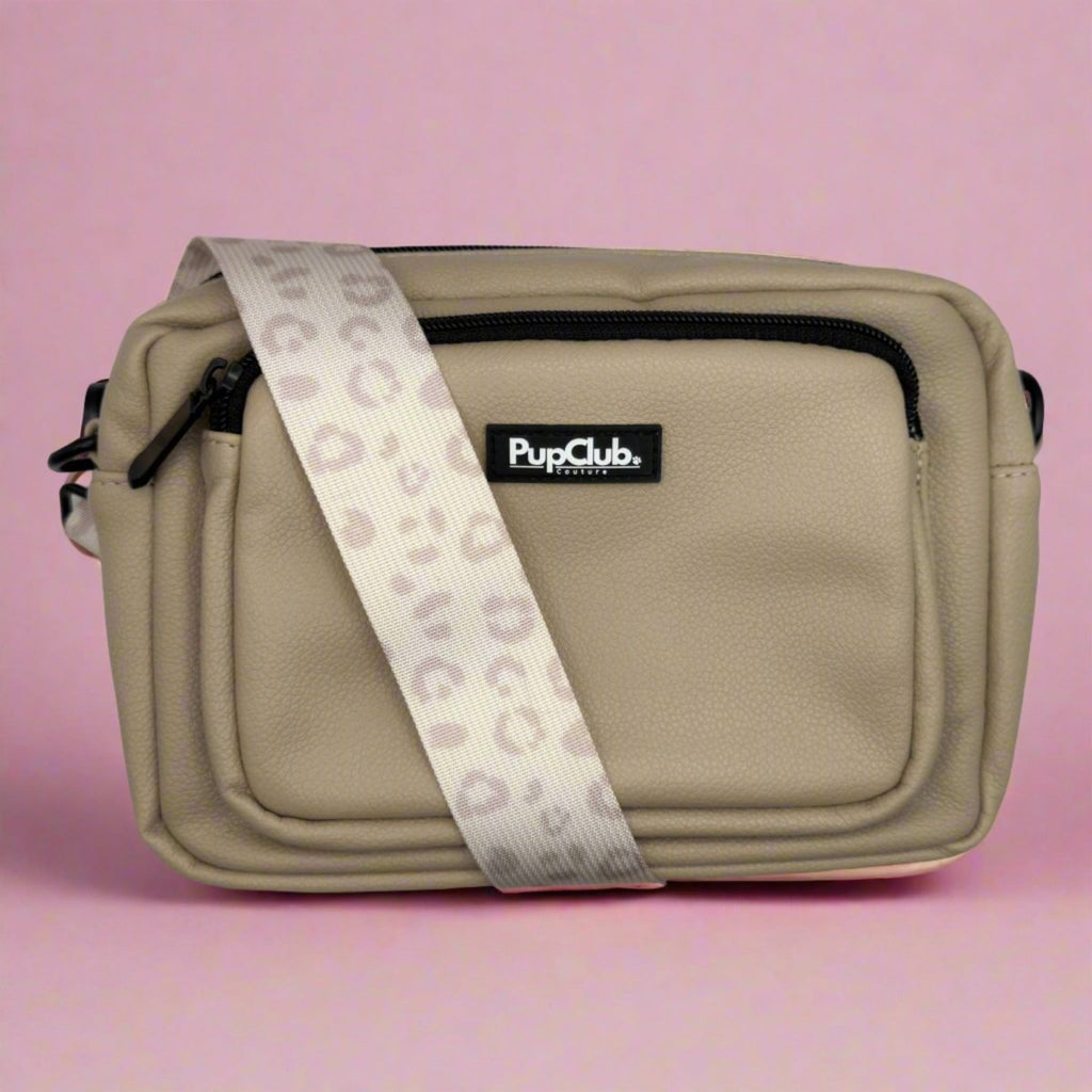 Tan vegan leather crossbody bag with front zip pocket and printed dog-walk strap