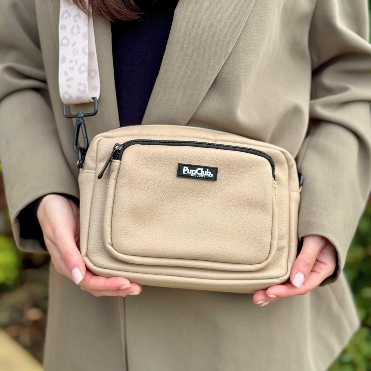 Tan vegan leather crossbody bag with black zipper and PupClub logo label
