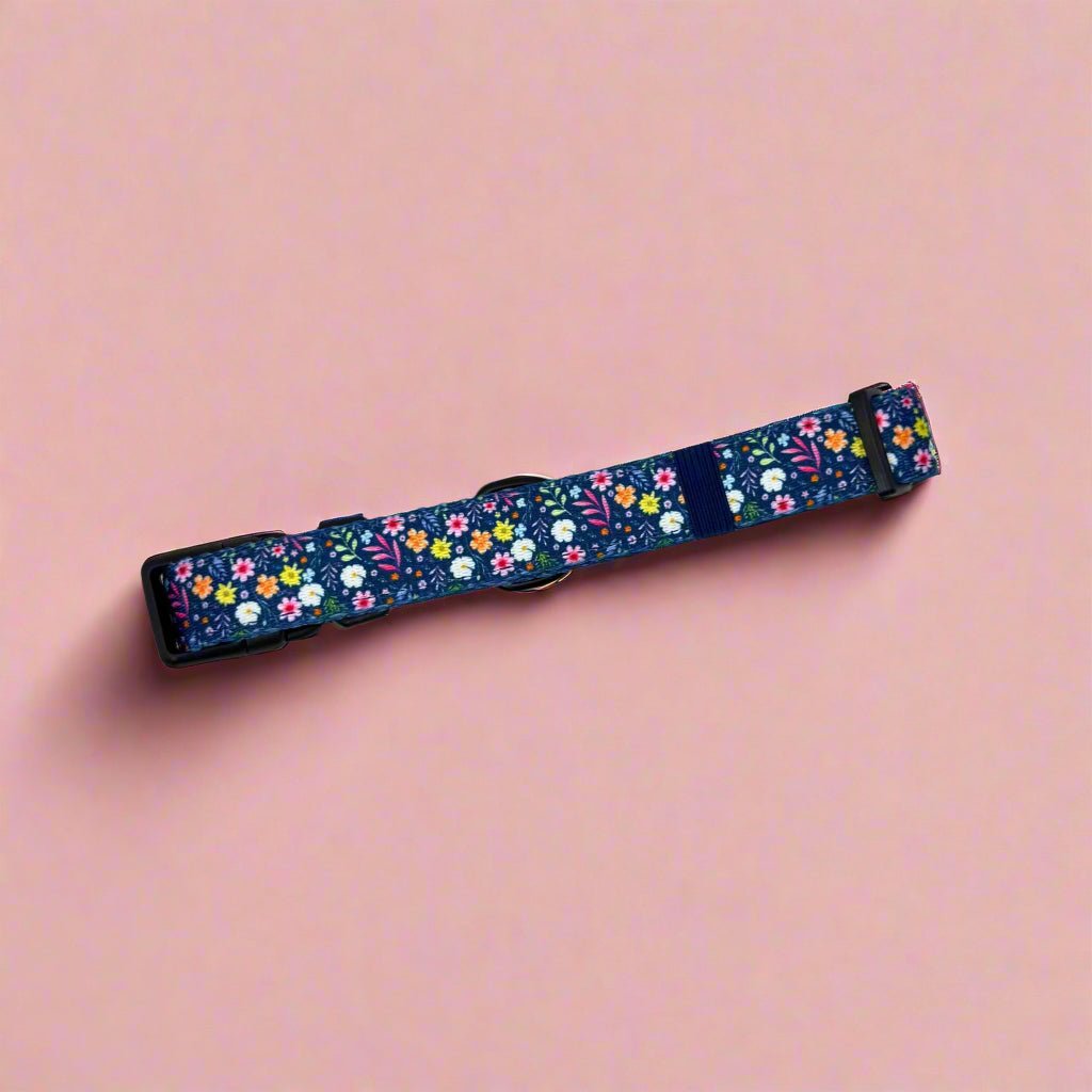 Dog collar with dark blue floral pattern on fabric webbing and black clasp.