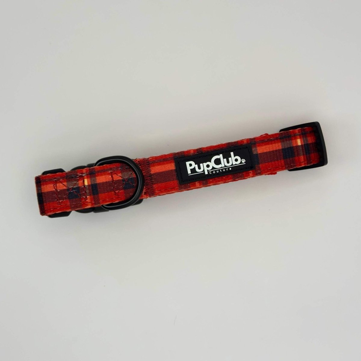 Red tartan dog collar with black buckle and PupClub logo