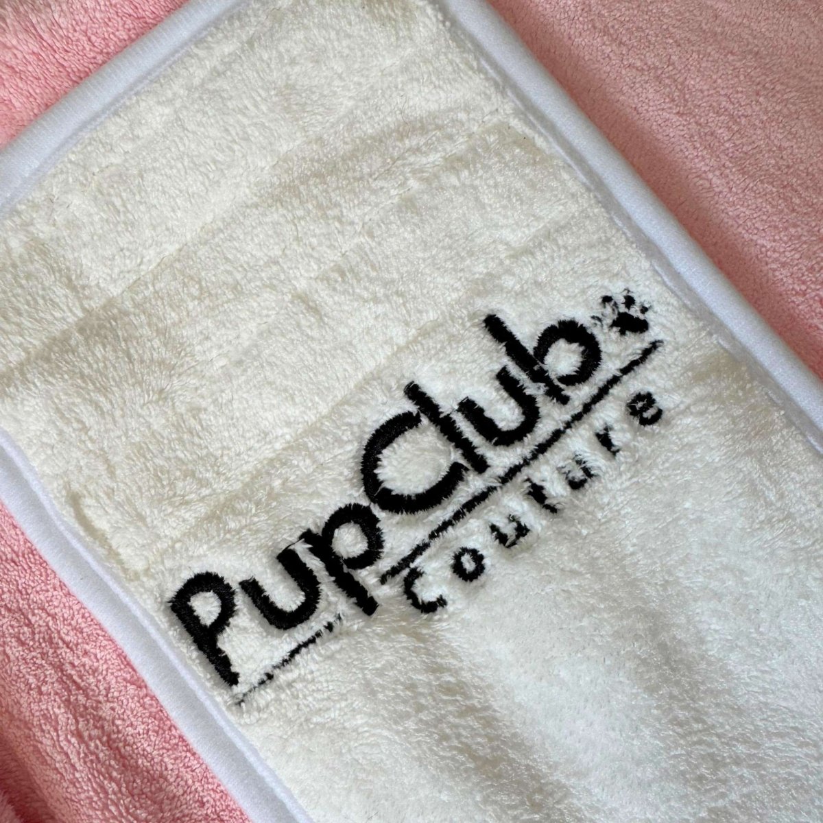 PupClub embroidered logo on light patch of a pink hooded drying robe