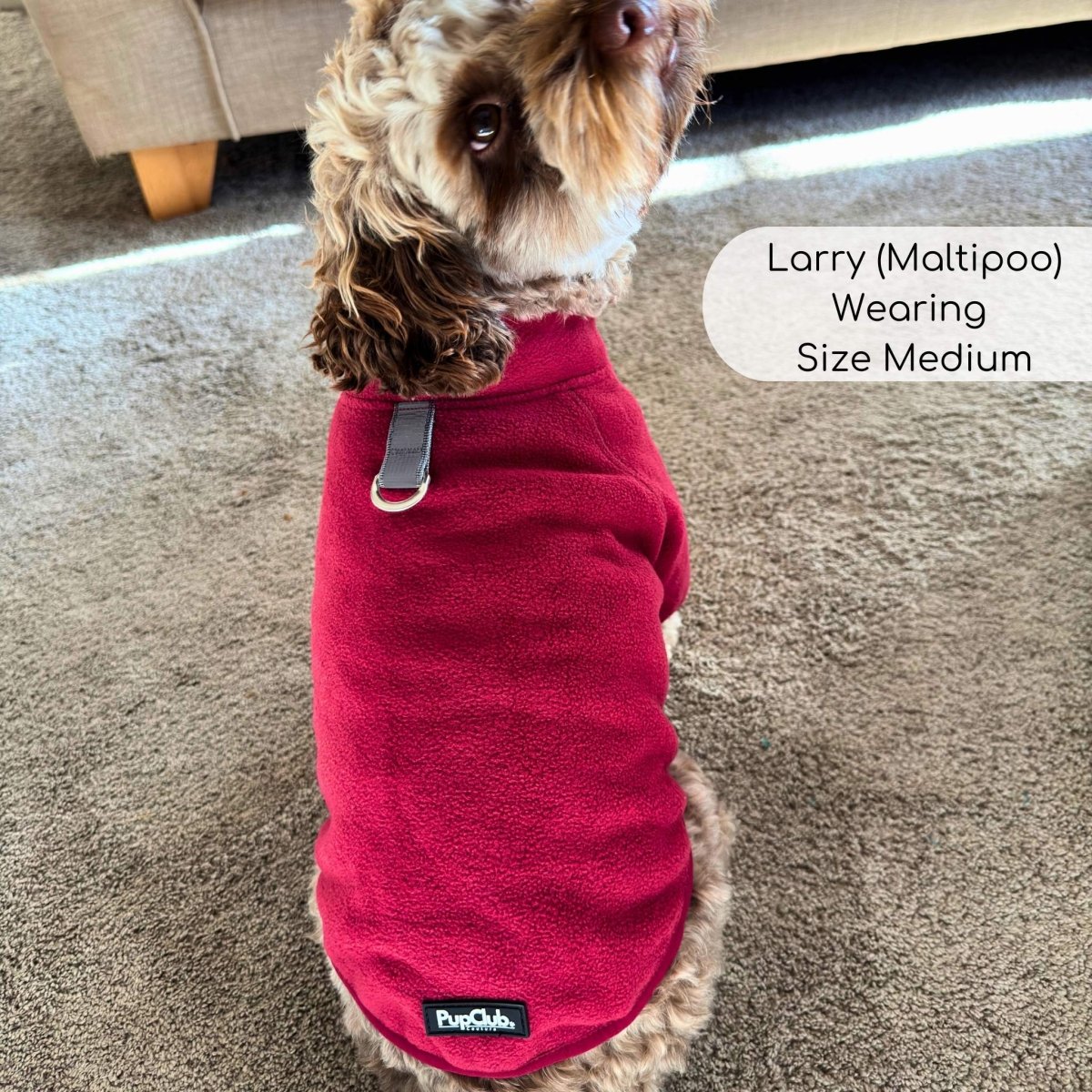 Berry red fleece dog coat with front zipper and logo patch at hem