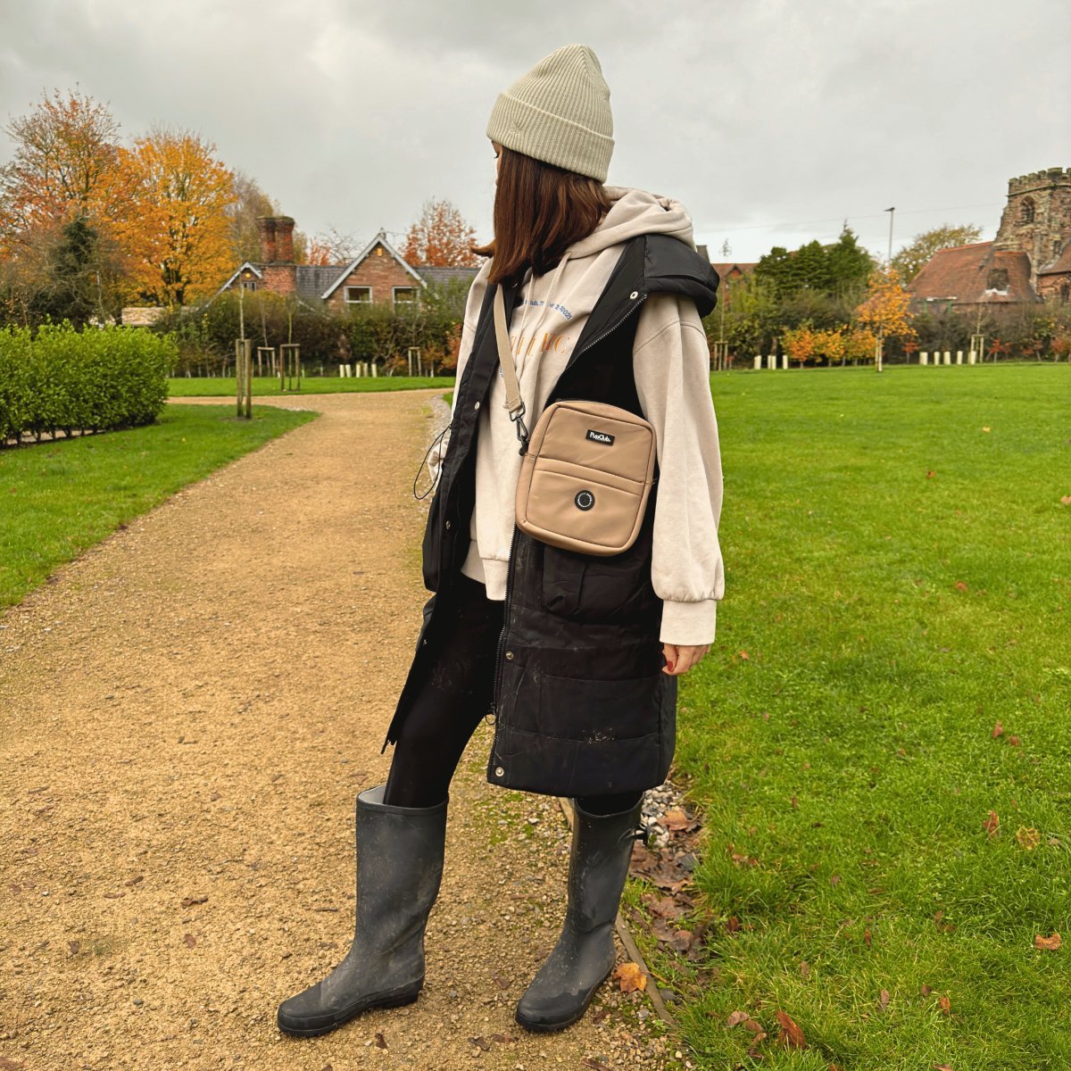 Tan mini dog walking bag with adjustable crossbody strap and front zip pocket