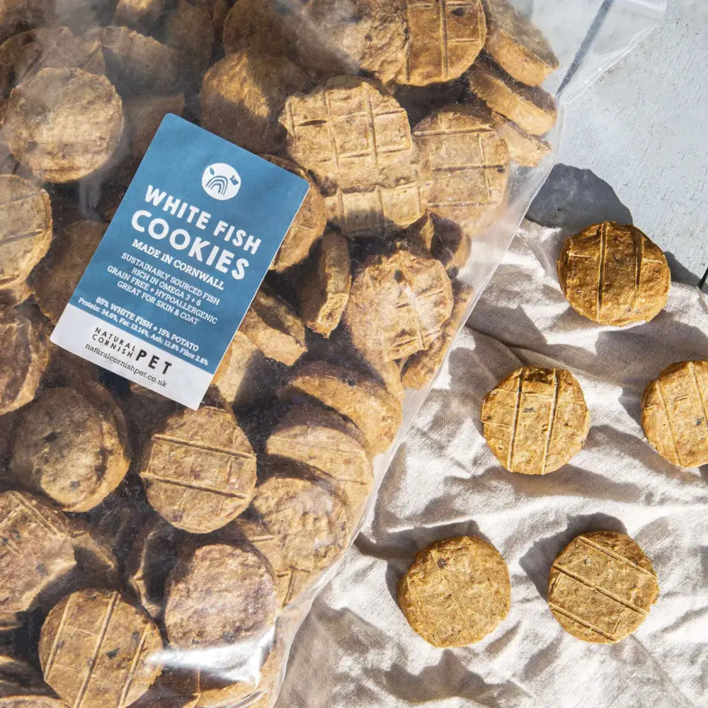 White fish pet cookies on parchment with a product label card