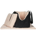 Black dog carrier with light pink plush lining and drawstring hood, side strap