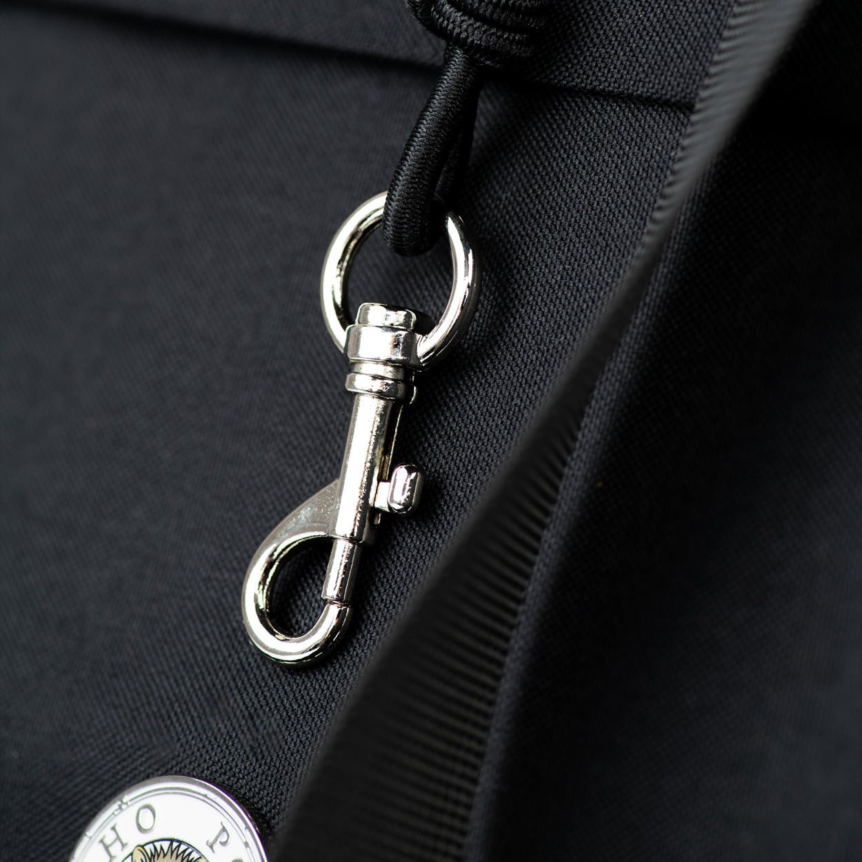Metal lobster clasp attachment on black pet carrier shoulder strap