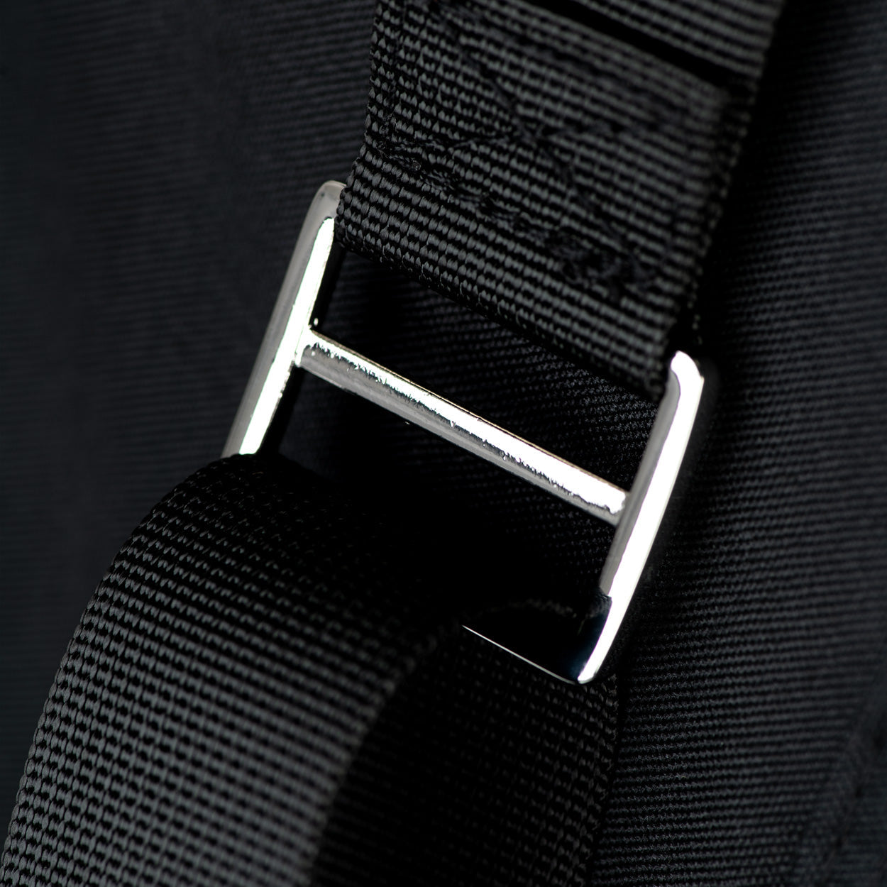 Black webbing strap with metal slider and adjustment buckle on pet carrier