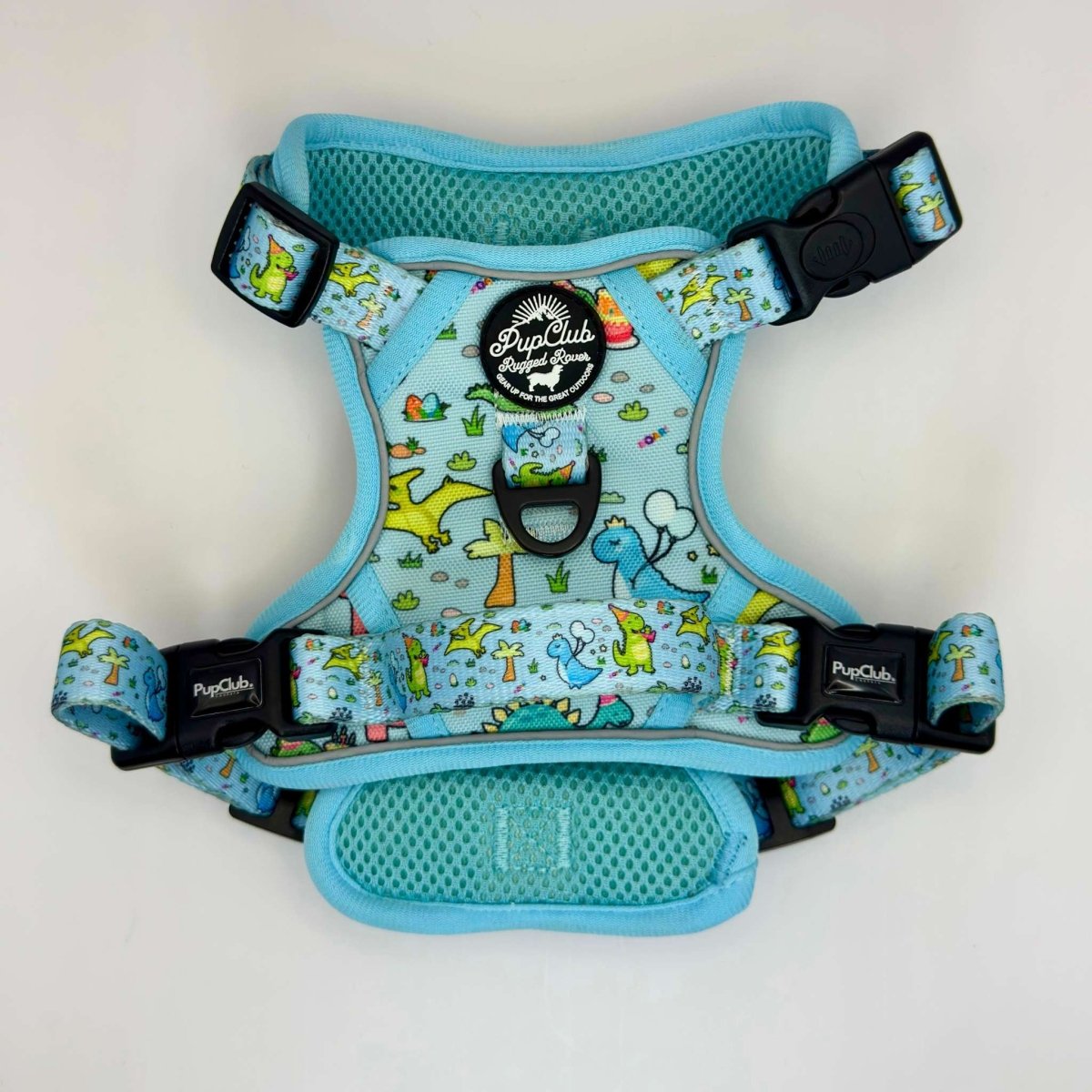 Blue dinosaur-print dog harness with mesh underside and black side buckles