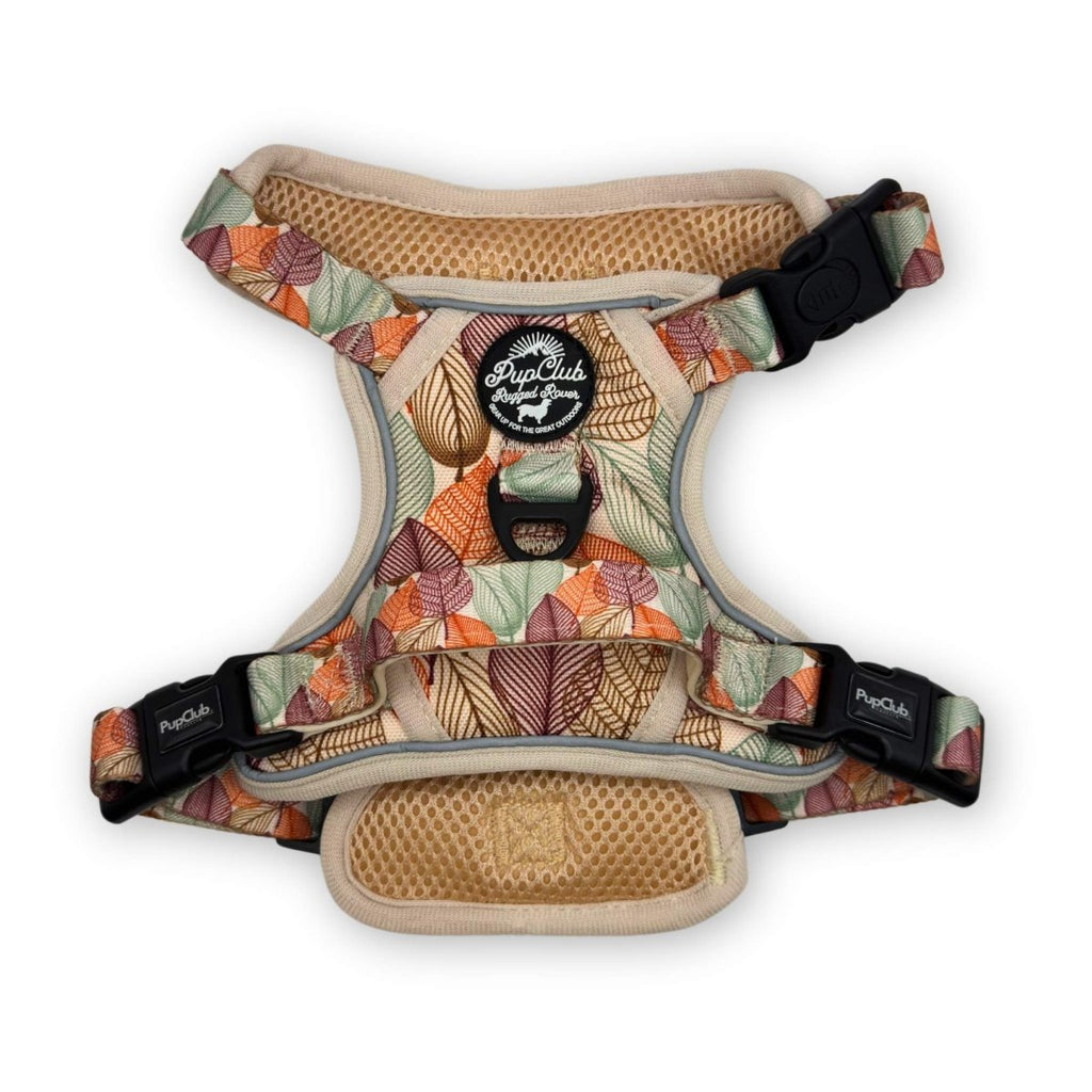 Dog harness with leaf-pattern fabric, tan trim, and black adjustable buckles