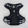Midnight black dog harness with front handle, chest strap, and white striped webbing