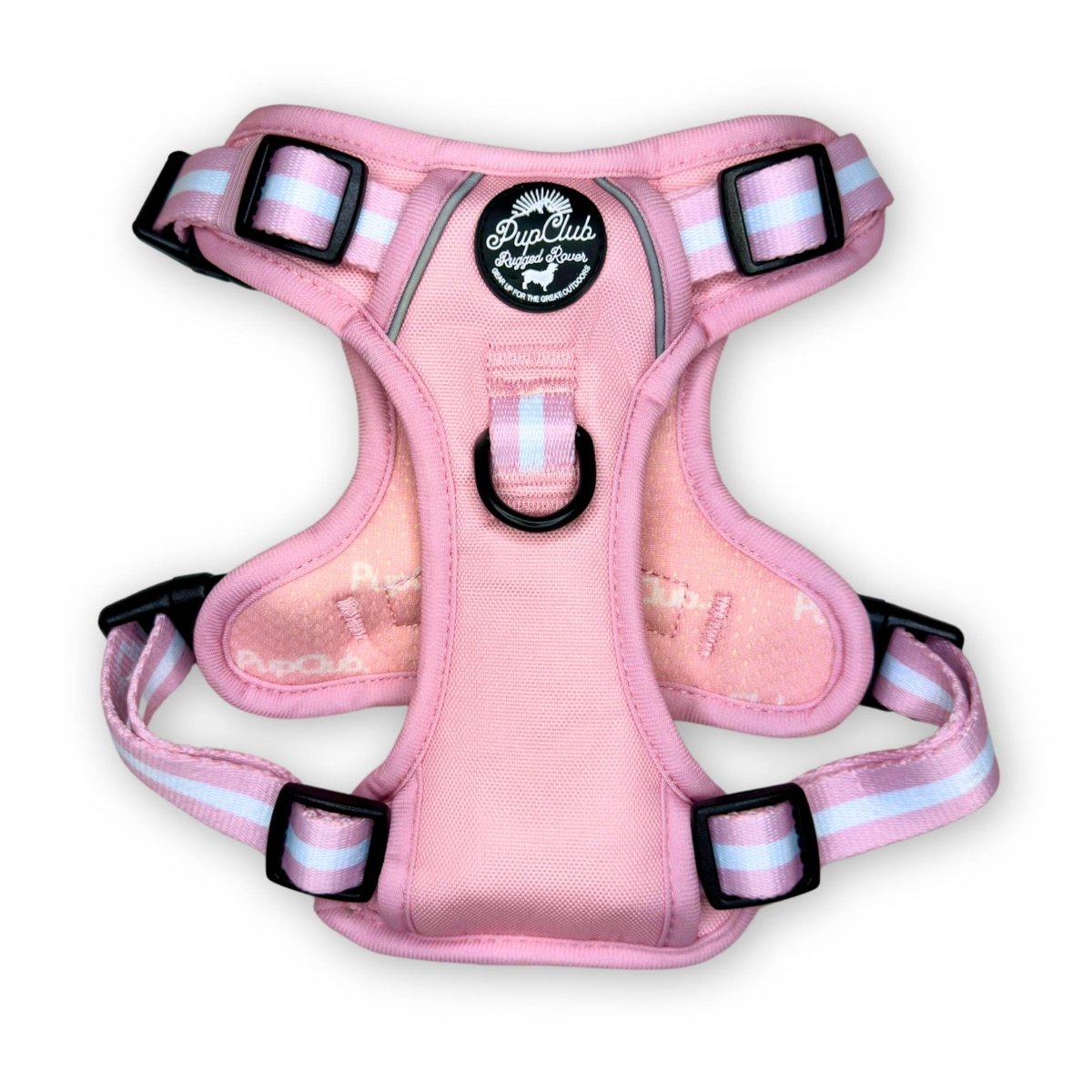 Pastel pink dog harness with black buckles and striped webbing at the straps