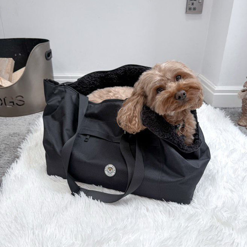 Black pet carrier with a small dog resting inside