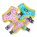 Reversible dog harness with pink-and-blue panels, yellow trim, and black hardware