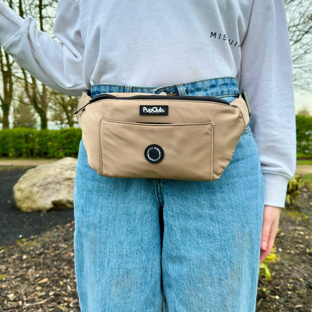 Tan bum bag close-up on waist with black zipper and PupClub logo